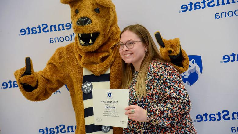 Psychology major Kylee Rishel poses with her certificate and the Nittany Lion after the induction ceremony. 